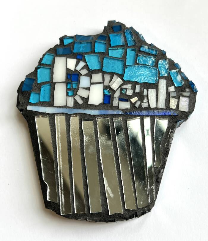 Mosaic cupcake, blue glass pieces as icing and mirror glass pieces as cupcake wrapper finished with black grout